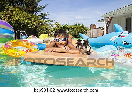 Boy and his Boston Terrier wearing matching goggles float on a toy in a pool View Large Photo Image Stock Image - Boy and his Boston Terrier wearing matching goggles float on a toy in a pool. Fotosearch