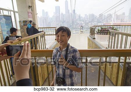 Boy being photographed in front of a Yangtze cable car View Large Photo Image Stock Image - Boy being photographed in front of a Yangtze cable car. Fotosearch