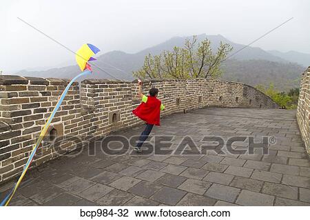 Stock Image - "Boy running with a kite on the Great Wall of China, at Mutianyu, Huairou, China". Fotosearch