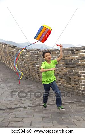 Stock Image - "Boy running with a kite on the Great Wall of China, at Mutianyu, Huairou, China". Fotosearch