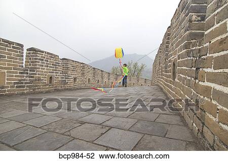 Stock Image - "Boy running with a kite on the Great Wall of China, at Mutianyu, Huairou, China". Fotosearch