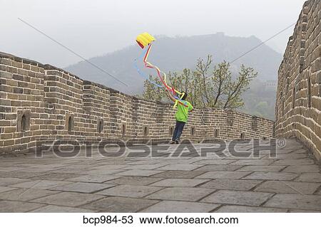 Stock Image - "Boy running with a kite on the Great Wall of China, at Mutianyu, Huairou, China". Fotosearch