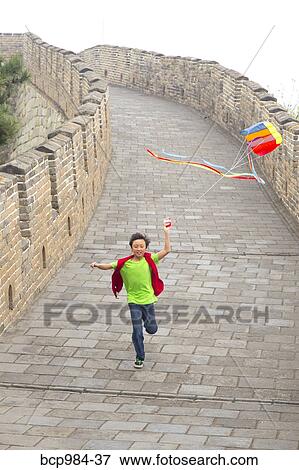 Stock Photo - "Boy running with a kite on the Great Wall of China, at Mutianyu, Huairou, China". Fotosearch