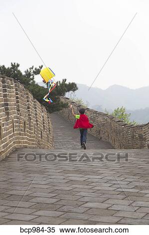 Stock Photography - "Boy running with a kite on the Great Wall of China, at Mutianyu, Huairou, China". Fotosearch