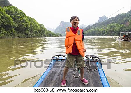 "Boy standing on a bamboo raft on the Li River, Yangshuo, China" View Large Photo Image Stock Photo - "Boy standing on a bamboo raft on the Li River, Yangshuo, China". Fotosearch