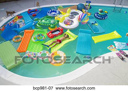 Boy wearing flippers floats in a pool full of inflatable toys View Large Photo Image Stock Photo - Boy wearing flippers floats in a pool full of inflatable toys. Fotosearch