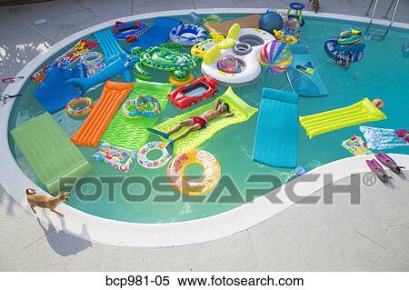 Boy wearing flippers floats in a pool full of inflatable toys View Large Photo Image Stock Photography - Boy wearing flippers floats in a pool full of inflatable toys. Fotosearch