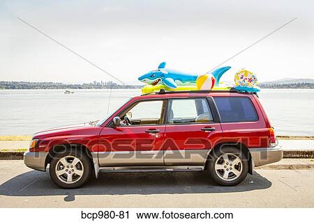 Car with beach toys and floaties on the roof parked by a lake View Large Photo Image Stock Image - Car with beach toys and floaties on the roof parked by a lake. Fotosearch