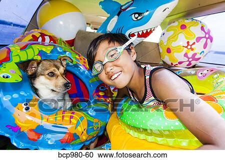 Child poses with his dog in a car full of beach toys and floaties View Large Photo Image Stock Image - Child poses with his dog in a car full of beach toys and floaties. Fotosearch