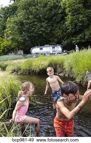 Children playing in a muddy creek View Large Photo Image Stock Photo - Children playing in a muddy creek. Fotosearch