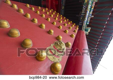 Stock Image - "Close up of the ornate red and gold palace gates in the Forbidden City, Beijing, China". Fotosearch