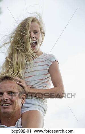 Father with his tween daughter on his shoulders on a windy day View Large Photo Image Stock Image - Father with his tween daughter on his shoulders on a windy day. Fotosearch