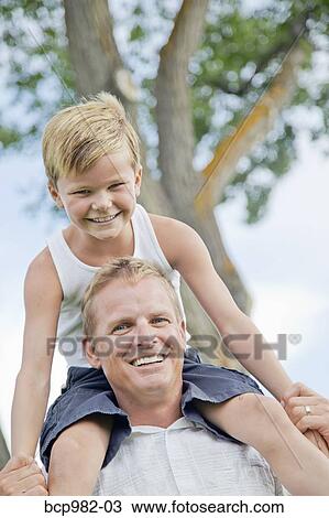 Father with his young son on his shoulders View Large Photo Image Stock Image - Father with his young son on his shoulders. Fotosearch