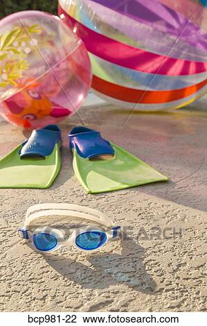 "Goggles, flippers, and beach balls next to a pool" View Large Photo Image Stock Image - "Goggles, flippers, and beach balls next to a pool". Fotosearch