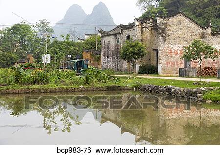 "Karst mountains and temple reflected in a village rice paddy, Yangshuo, China" View Large Photo Image Stock Photograph - "Karst mountains and temple reflected in a village rice paddy, Yangshuo, China". Fotosearch