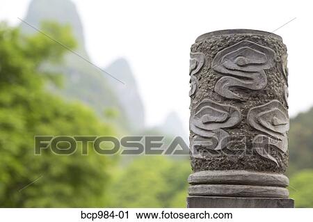 "Karst mountains behind a carved stone pillar, Yangshuo, China" View Large Photo Image Stock Image - "Karst mountains behind a carved stone pillar, Yangshuo, China". Fotosearch