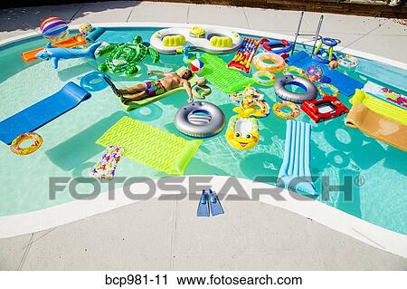 Man wearing flippers floats in a pool full of inflatable toys View Large Photo Image Stock Image - Man wearing flippers floats in a pool full of inflatable toys. Fotosearch