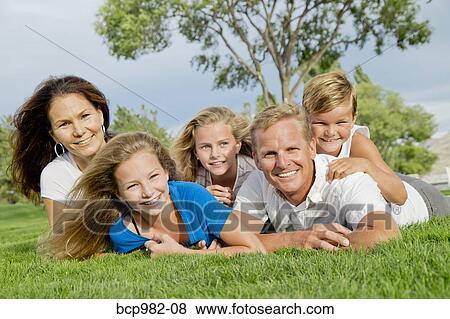 Portrait of a family of five in a dog pile near a lake View Large Photo Image Stock Photo - Portrait of a family of five in a dog pile near a lake. Fotosearch