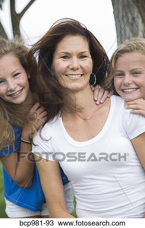 Stock Image - Portrait of a mother with her two tween daughters. Fotosearch