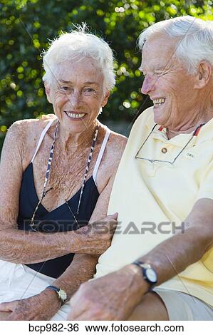 Portrait of a senior couple sitting outdoors View Large Photo Image Stock Photograph - Portrait of a senior couple sitting outdoors. Fotosearch