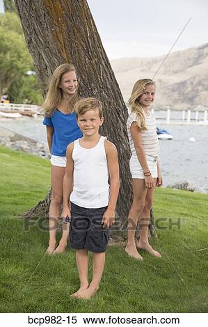 Portrait of three children by a tree near a lake View Large Photo Image Stock Photography - Portrait of three children by a tree near a lake. Fotosearch
