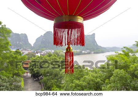 Picture - "Red lantern hanging in front of a view of the Karst mountains and Li River, Yangshuo, China". Fotosearch