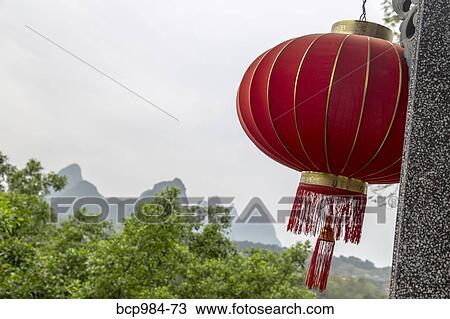 "Red lantern hanging in front of a view of the Karst mountains, Yangshuo, China" View Large Photo Image Stock Image - "Red lantern hanging in front of a view of the Karst mountains, Yangshuo, China". Fotosearch