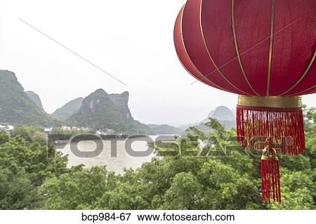 "Red lantern hanging in front of a view of the Karst mountains and Li River, Yangshuo, China" View Large Photo Image Stock Photo - "Red lantern hanging in front of a view of the Karst mountains and Li River, Yangshuo, China". Fotosearch