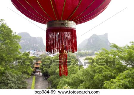 "Red lantern hanging in front of a view of the Karst mountains and Li River, Yangshuo, China" View Large Photo Image Stock Photo - "Red lantern hanging in front of a view of the Karst mountains and Li River, Yangshuo, China". Fotosearch
