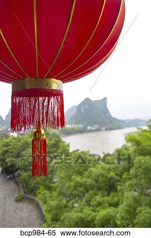 "Red lantern hanging in front of a view of the Karst mountains and Li River, Yangshuo, China" View Large Photo Image Stock Photography - "Red lantern hanging in front of a view of the Karst mountains and Li River, Yangshuo, China". Fotosearch