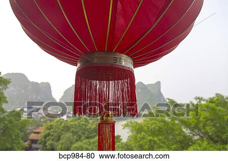 Stock Image - "Red lantern hanging in front of the Li River, Yangshuo, China". Fotosearch