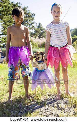 Small dog in a tutu with his paws held up by children in tutus View Large Photo Image Picture - Small dog in a tutu with his paws held up by children in tutus. Fotosearch