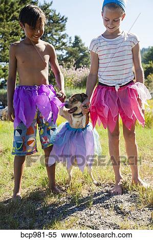 Small dog in a tutu with his paws held up by children in tutus View Large Photo Image Stock Photography - Small dog in a tutu with his paws held up by children in tutus. Fotosearch
