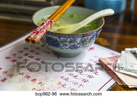 Soup bowl and chopsticks at a Chinese restaurant View Large Photo Image Stock Photograph - Soup bowl and chopsticks at a Chinese restaurant. Fotosearch