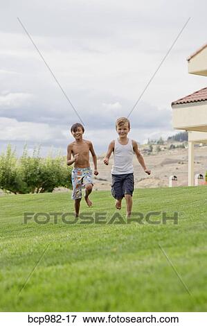 Stock Photo - Two boys running on grass. Fotosearch