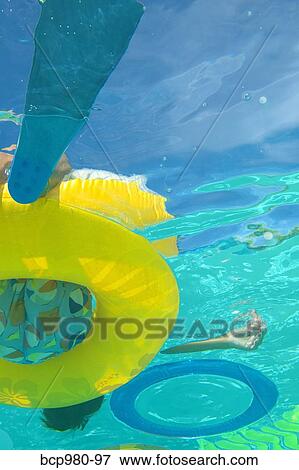 Underwater view of a boy sitting in a pool floatie View Large Photo Image Stock Photo - Underwater view of a boy sitting in a pool floatie. Fotosearch