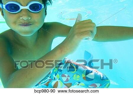 Underwater view of a boy swimming wearing goggles View Large Photo Image Stock Image - Underwater view of a boy swimming wearing goggles. Fotosearch