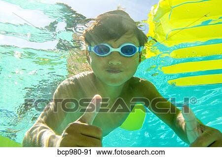 Underwater view of a boy swimming wearing goggles View Large Photo Image Stock Image - Underwater view of a boy swimming wearing goggles. Fotosearch