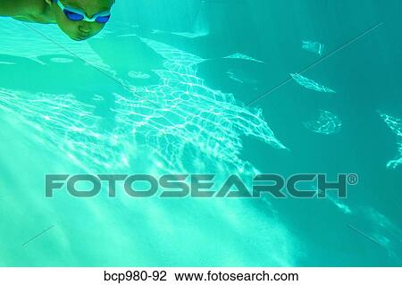 Underwater view of a boy swimming wearing goggles View Large Photo Image Stock Image - Underwater view of a boy swimming wearing goggles. Fotosearch
