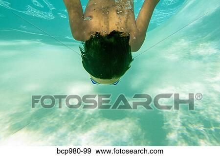 Underwater view of a boy swimming wearing goggles View Large Photo Image Stock Photo - Underwater view of a boy swimming wearing goggles. Fotosearch