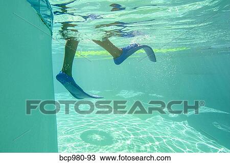 Stock Image - Underwater view of a boy wearing flippers. Fotosearch