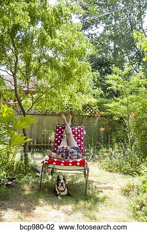 Woman with rollers in her hair lounges in her garden with a Boston Terrier View Large Photo Image Stock Image - Woman with rollers in her hair lounges in her garden with a Boston Terrier. Fotosearch