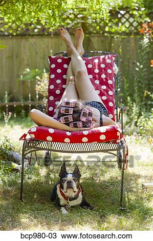 Woman with rollers in her hair lounges in her garden with a Boston Terrier View Large Photo Image Stock Image - Woman with rollers in her hair lounges in her garden with a Boston Terrier. Fotosearch