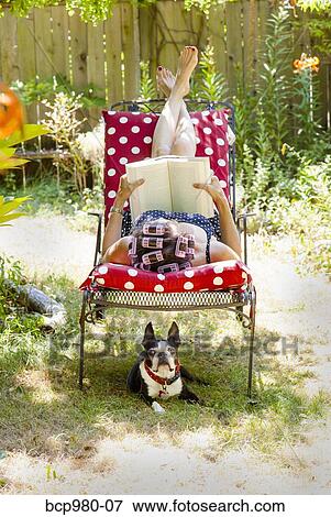 Woman with rollers in her hair reads in her garden with a Boston Terrier View Large Photo Image Stock Photo - Woman with rollers in her hair reads in her garden with a Boston Terrier. Fotosearch