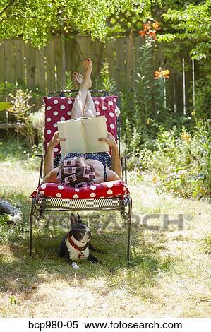 Woman with rollers in her hair reads in her garden with a Boston Terrier View Large Photo Image Stock Photography - Woman with rollers in her hair reads in her garden with a Boston Terrier. Fotosearch