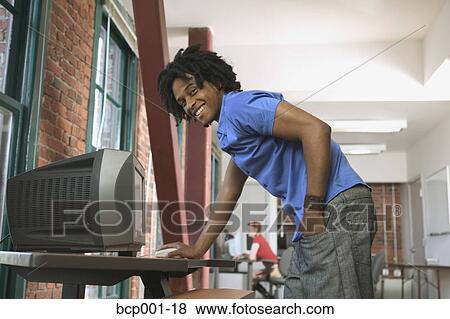 A smiling man standing at a computer terminal. View Large Photo Image Stock Photo - A smiling man standing at a computer terminal.. Fotosearch