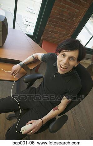 A tattooed worker smiling in his office. View Large Photo Image Stock Photograph - A tattooed worker smiling in his office.. Fotosearch
