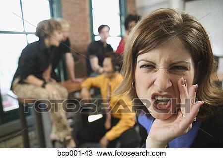 Stock Image - A woman gossiping in an office.. Fotosearch