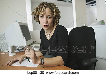 A woman working at her desk. View Large Photo Image Stock Image - A woman working at her desk.. Fotosearch