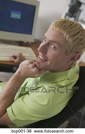 A young man working at his desk. View Large Photo Image Stock Photo - A young man working at his desk.. Fotosearch